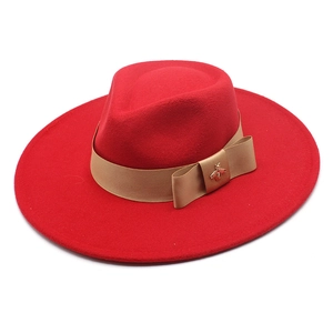 Detailed view of the red wool felt fedora featuring a silk band and gold bee buckle