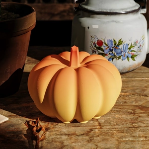 Detail of creative orange pumpkin resin ornament with matte finish on wooden base