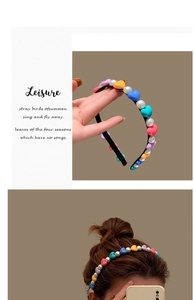Detail of colorful heart resin beads and white pearls on a slim black headband base