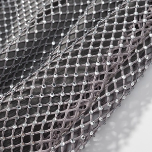 Vue détaillée du tissu en maille grise avec strass brillants sur une robe courte