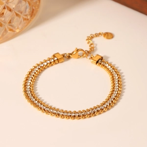 Detail of gold layered bead and zircon chain bracelet with adjustable lobster clasp closure