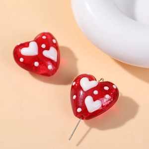 Detail of red heart-shaped glass beads with white polka dots for DIY jewelry making
