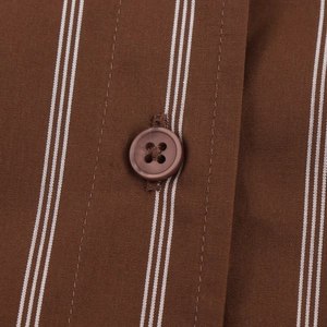 Detailed macro view of brown striped shirt fabric with a classic four-hole button