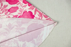 Gros plan sur l'imprimé floral rose et les détails de couture soignés sur l'ourlet de la robe