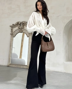 Detail of white puff-sleeve shirt with retro full-length mirror and brown handbag