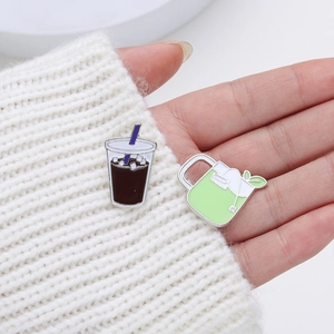 Creative enamel pins set featuring iced coffee and green tea cup designs on white knit