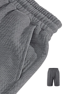 Dettaglio dei pantaloncini in maglia grigia con trama a nido d'ape e vita elastica