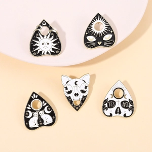 Detail of five occult enamel pins featuring moon cats and skulls with gold plating