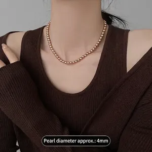 Élégant collier de perles en or rose de 4 mm porté sur un pull en maille douce