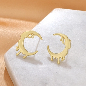 Vintage golden lava droplet earrings on white marble with orange silk background