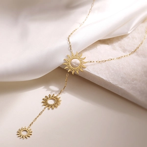 18K gold plated stainless steel necklace with three sunburst floral pendants on white silk