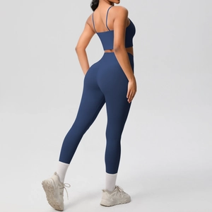 Detailed side view of navy blue high-waisted yoga leggings and strappy sports bra set