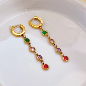 Detailed macro view of gold-plated hoop earrings with vibrant multi-colored gemstones