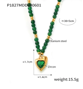 Détail du pendentif cœur en acier titane avec zircon vert sur collier de perles