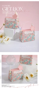 Detail of pink and blue European wedding candy boxes with floral patterns and handles