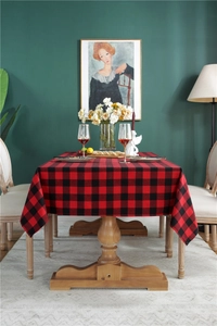 Cozy dining scene with a red and black plaid rectangle tablecloth on a wooden table