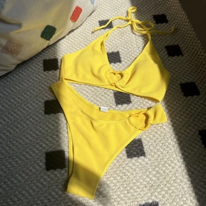 Yellow heart-accented bikini set with textured fabric and stylish halter tie top
