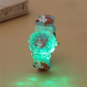 Close-up of kids unicorn watch featuring glowing green LED light effect on blue strap