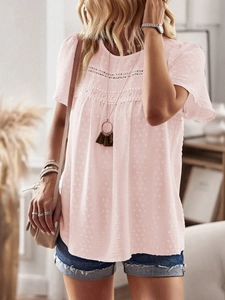 Detail of light pink short sleeve top featuring delicate lace stitching and polka dot texture