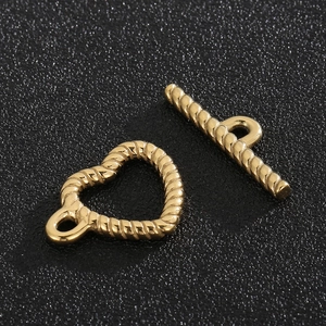 Macro shot of gold-plated twisted rope toggle clasp with heart ring and bar for DIY jewelry