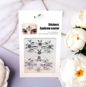 3D eyebrow art stickers with iridescent gems and glitter on white card packaging