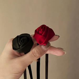 Detailed close-up of handmade fabric rose necklaces in classic red and black silk satin