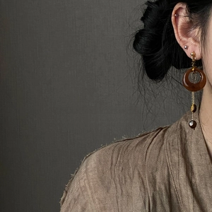 Close-up of model wearing retro resin tiger eye stone long asymmetric dangle earrings