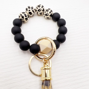 Detail of silicone beaded wristlet keychain with leopard print tassel and wooden bead