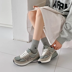 Detail of grey cotton striped crew socks featuring a small bee embroidery on the ankle