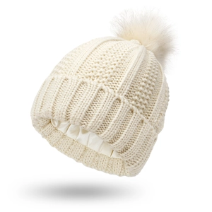 Detail of knit beanie with satin lining and a fluffy faux fur pompom for hair protection