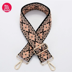 Detail of pink and black geometric woven bag strap with gold metal lobster clasps