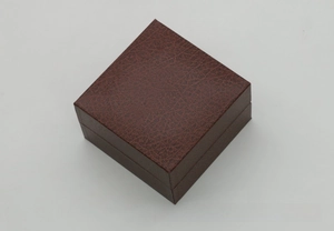 Top view detail of a dark brown square watch box with realistic faux leather crocodile texture