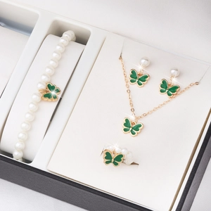 Gros plan sur l'ensemble bijoux papillon et perles avec collier et boucles d'oreilles