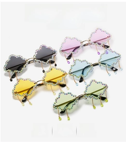 Detail of cloud-shaped sunglasses with shimmering rhinestones and metal chain tassels
