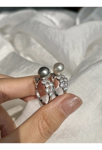 Macro shot of silver lace rings featuring grey and white pearls with sparkling zircons