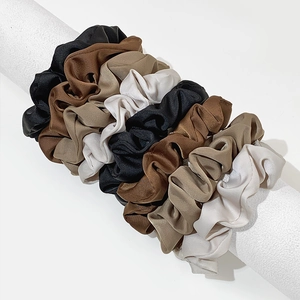 Satin silk scrunchies set in elegant coffee tones on a vertical display stand