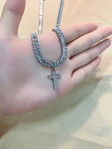 Close-up of a silver cross necklace with sparkling cubic zirconia on a luxury chain