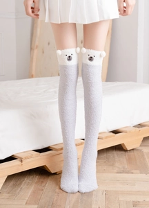 Detail of fluffy coral fleece over-knee socks with cute grey and white bear ears design