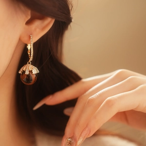 Close-up of leopard print ball earring with sparkling zircon details on model