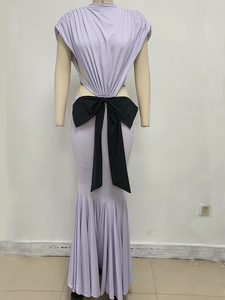 Detail of light purple mermaid dress featuring a large black waist bow and backless cut