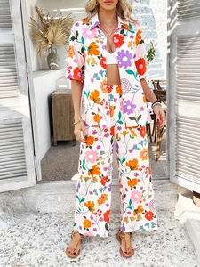 Detail of vibrant floral print on short sleeve shirt and high waist wide leg pants set