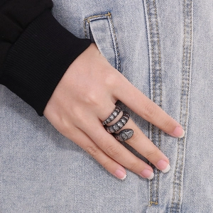 Detail of silver vintage snake ring with textured scales worn on a model in denim