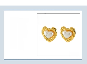 Detailed view of gold plated heart earrings with pearl inlay and hammered texture