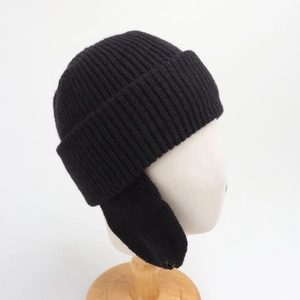 Detail view of black ribbed knit winter hat for kids with earflaps on white mannequin head