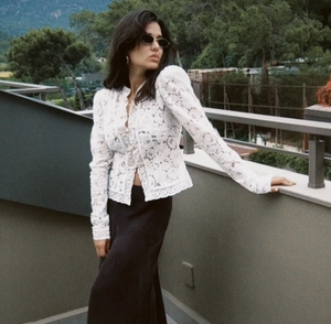 Foto exterior de blusa blanca de encaje de manga larga con bordado floral elegante