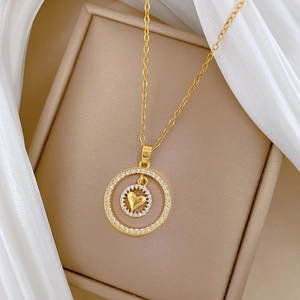 Dettaglio della collana a doppio anello a cuore con cristalli su portagioie beige