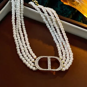 Luxurious layered pearl necklace with sparkling gold crystal initial pendant design