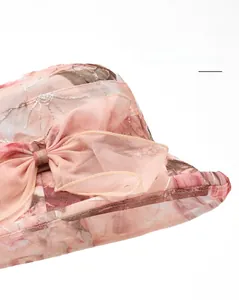 Close-up of pink organza sun hat with silver floral embroidery and a large bow detail