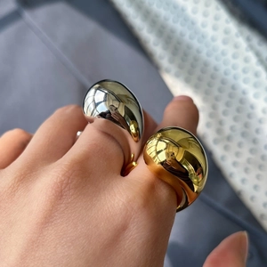 Close-up of teardrop shaped silver and gold rings with polished mirror surface