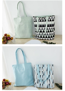 Detail of mint green and light blue canvas tote bags with geometric triangle patterns